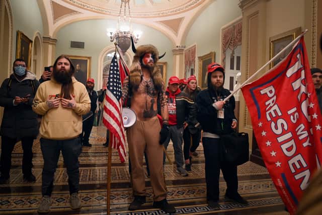 Supporters of US President Donald Trump, including member of the QAnon conspiracy group Jake Angeli, aka Yellowstone Wolf (C), enter the US Capitol on January 6, 2021, in Washington, DC.