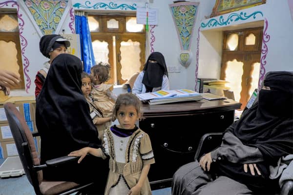 Women wait with children before medical examinations at al-Janatain Charity Medical Centre in Yemen’s Huthi-rebel-held capital Sanaa on March 14, 2023. (Photo by Mohammed HUWAIS / AFP via Getty Images)