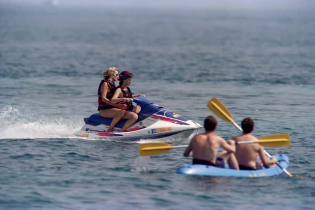 Photo taken on July 14, 1997 shows Britain's Lady Diana taken by an unidentified young girl for a jet-ski ride off the property of her friend Dodi Al-Fayed in Saint Tropez, on the French Riviera.(Photo by Patrick HERTZOG / AFP) 
