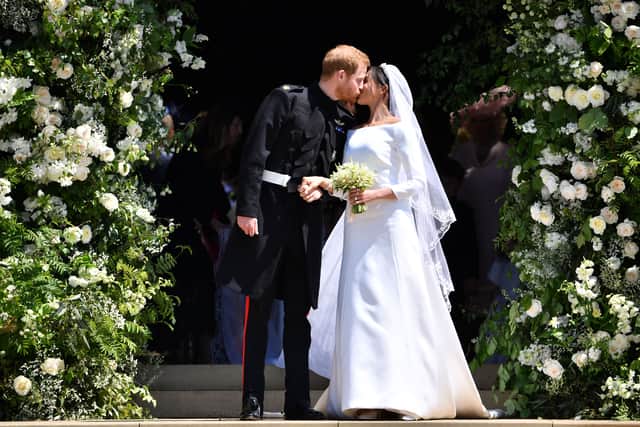 TOPSHOT - Britain's Prince Harry, Duke of Sussex kisses his wife Meghan, Duchess of Sussex as they leave from the West Door of St George's Chapel, Windsor Castle, in Windsor, on May 19, 2018 after their wedding ceremony. (Photo by Ben STANSALL / POOL / AFP)        (Photo credit should read BEN STANSALL/AFP via Getty Images)