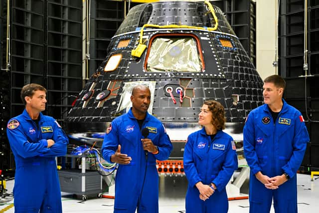 The crew of Artemis II (L-R) US astronauts Reid Wiseman, commander; Victor Glover, pilot; Christina Hammock Koch, mission specialist; and Canadian astronaut Jeremy Hansen, mission specialist, speak in front of the Artemis II crew module (rear) inside the Neil Armstrong Operations and Checkout Building at the Kennedy Space Center in Cape Canaveral, Florida, on August 8, 2023. (Photo by CHANDAN KHANNA/AFP via Getty Images)