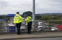 Police officers watch the M25 motorway near Heathrow Airport. The number of reports of vehicles being driven the wrong way on England's motorways rose by 13% in a year, an investigation has found Picture: PA