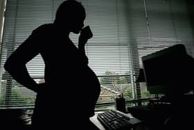In this photo illustration a pregnant woman is seen stood at the office work station on July 18, 2005 in London, England. Credit: Daniel Berehulak / Getty Images