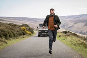 Jamie Dornan as Elliot Stanley in The Tourist Season 2, being chased down a road by a land rover (Credit: BBC/Two Brothers/Steffan Hill)