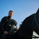 Iain De Caestecker as Arthur Pendragon in The Winter King, riding on horseback (Credit: ITVX)