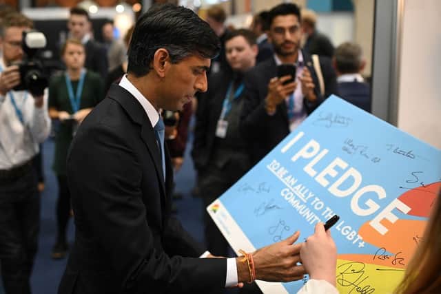 Rishi Sunak, who was then Chancellor, signs his name on a pledge to be an ally to the LGBTQ+ community at their stand on the second day of the annual Conservative Party Conference which was being held at the Manchester Central convention centre in Manchester, northwest England, on October 4, 2021. Credit: Getty Images