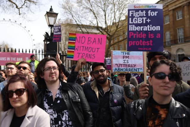 Demonstrators hold placards during the No Ban Without Trans protest opposite Downing Street on April 10, 2022 in London, England. LGBTQ+ collectives and supporters are taking to the streets to protest against the UK Government's decision not to ban trans conversion therapies. (Photo by Hollie Adams/Getty Images)