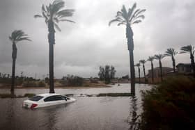 A car is partially submerged in floodwaters as Tropical Storm Hilary moves through the area on August 20, 2023 in Cathedral City, California. (Photo by Mario Tama/Getty Images)