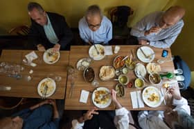 People eat lunch inside the India Club restaurant in London (CHRIS J RATCLIFFE/AFP via Getty Images)