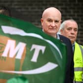 Secretary-General of the National Union of Rail, Maritime and Transport Workers (RMT) Mick Lynch stands with union members at a picket line outside Euston Station