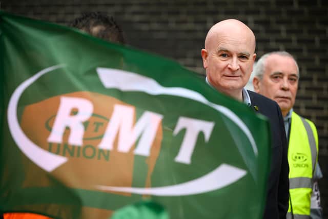 Secretary-General of the National Union of Rail, Maritime and Transport Workers (RMT) Mick Lynch stands with union members at a picket line outside Euston Station