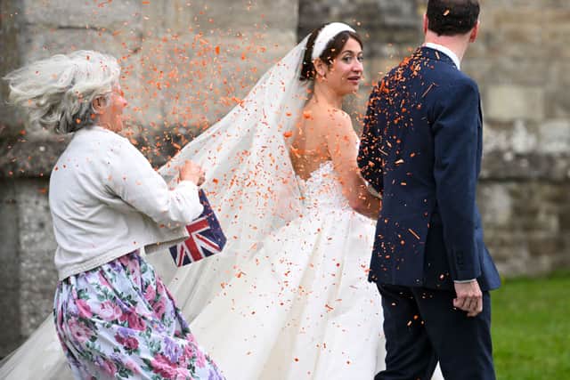 A woman throws confetti as former UK Chancellor George Osborne and Thea Rogers leave after their wedding at St Mary's Church, on July 8, 2023 in Bruton, England. (Photo by Finnbarr Webster/Getty Images)