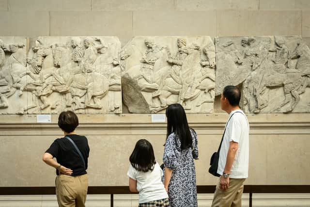 Visitors to the British Museum walk around a selection of items from the collection of ancient Greek sculptures known as The Elgin Marbles. (Photo by Leon Neal/Getty Images)