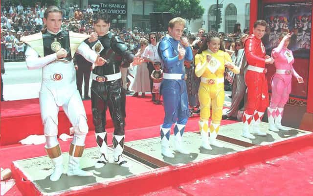 The Mighty Morphin Power Rangers strike poses as they stand in cement at Mann's Chinese Theater in Hollywood.  From L to R are: Jason Frank, Johnny Yong Bosch, David Yost, Karan Ashley, Steve Cardenas and Amy Jo Johnson. (MIKE NELSON/AFP via Getty Images)