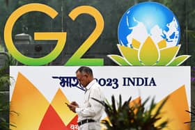 A pedestrian walks past a G20 summit logo installed along a street in New Delhi 6 September 6 2023 (Photo: SAJJAD HUSSAIN/AFP via Getty Images)