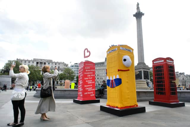People take photographs of decorated replica K6 kiosk telephone boxes on display in Trafalgar Square in central London on June 15, 2012. (LEON NEAL/AFP/GettyImages)