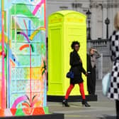 People walk amid decorated replica K6 kiosk telephone boxes on display in Trafalgar Square in central London on June 15, 2012. (LEON NEAL/AFP/GettyImages)