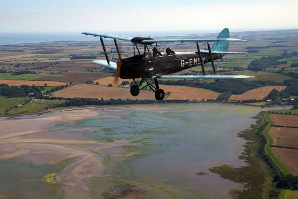 The World War II vintage Tiger Moth plane takes to the sky over Northumberland. (PA)