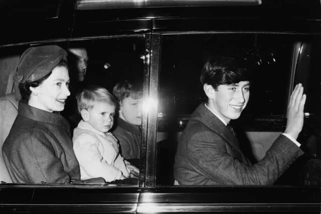 Queen Elizabeth II and her family traveling to Sandringham in the back of their car, with Prince Andrew on her lap, the Duke of Edinburgh to her left with Princess Anne on his lap, and Prince Charles (right) waving, arriving at Liverpool Street Station, London, January 27th 1966. (Photo by Douglas Miller/Keystone/Getty Images)