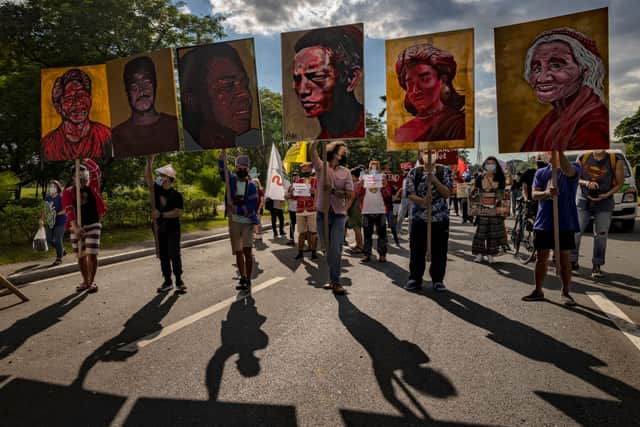 Climate activists hold up portraits of slain Philippine environmental defenders in 2021 (Photo by Ezra Acayan/Getty Images)