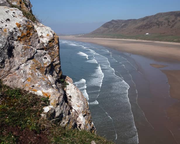 Waves break on the beach viewed from the cliffs at Worm's Head near Rhossili on the Gower Peninsula, Wales (Photo: Matt Cardy/Getty Images)