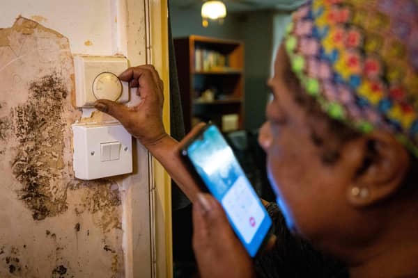 Doreen Thompson adjusts her thermostat as she limits her use of heating to keep up with increasing energy bills, at her home in south London.