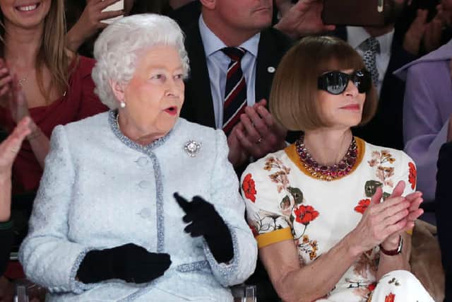 The late Queen Elizabeth II, accompanied by British-American journalist and editor, Anna Wintour (R), views British designer Richard Quinn's runway show before presenting him with the inaugural Queen Elizabeth II Award for British Design, during her visit to London Fashion Week's BFC Show Space in central London on February 20, 2018. (Photo by Yui Mok / POOL / AFP) (Photo by YUI MOK/POOL/AFP via Getty Images)