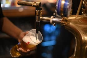 An employee pours a pint of Peroni beer on at the bar in the Mad Hatter pub and hotel in London. (Photo by DANIEL LEAL/AFP via Getty Images)