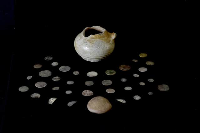 Photo of a coin hoard, pot and lid discovered by archaeology student Lucy Ankers, hidden under a fireplace during an archaeological dig (Gareth Beale/PA Wire)