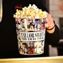 TOPSHOT - A tub of popcorn in US singer Taylor Swift's merchandise is pictured during the "Taylor Swift: The Eras Tour" concert movie world premiere at AMC Century City theatre in Century City, California on October 12, 2023. (Photo by Frederic J. BROWN / AFP) (Photo by FREDERIC J. BROWN/AFP via Getty Images)