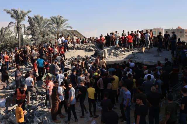 Palestinians gather at the site of a collapsed building following an Israeli airstrike in Rafah, in the southern part of Gaza Strip. Credit: Getty