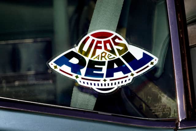 A sticker declares the existence of flying saucers from the window of a car parked on property near Jamul, CA, October 15, 2000. (Image: David McNew/Newsmakers)