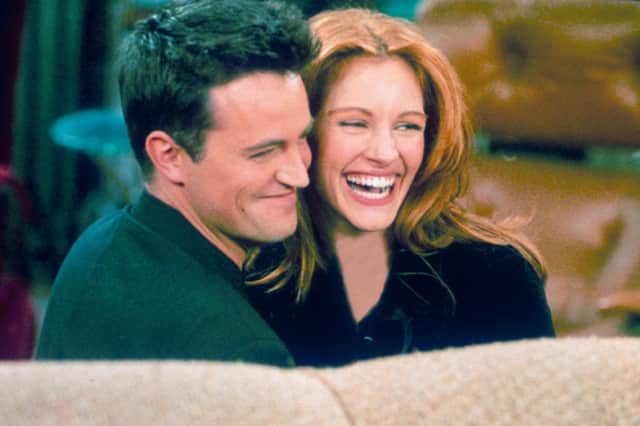 Matthew Perry previously dated Julia Roberts, who appeared on an episode of Friends. The couple hug each other on the set of "Friends." (Photo by Liaison)