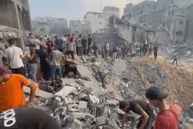 This image grab taken from AFPTV video footage shows Palestinians looking for survivors in a crater following a stike on a refugee camp in Jabalia on the northern Gaza Strip, on October 31, 2023, amid relentless Israeli bombardment of the Palestinian territory. (Photo by FADI ALWHIDI/AFP via Getty Images)