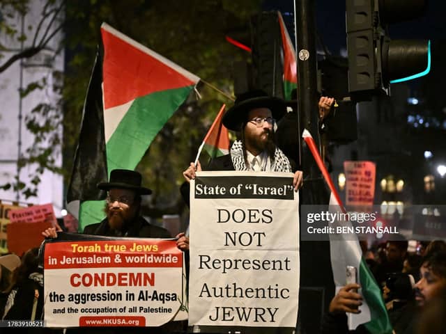 Members of the Ultra-Orthodox Jewish community hold placards during a rally in support of Palestinians, outside of the Houses of Parliament in central London on November 15, 2023, to demand Members of Parliament vote for a ceasefire in Gaza. (Photo by BEN STANSALL/AFP via Getty Images)
