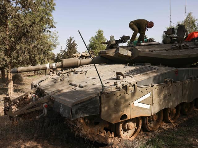 An Israeli soldier stands atop a tank near the border with the Gaza Strip in southern Israel on November 26, 2023, amid a cease fire following weeks of battles between Israel and Palestinian Hamas militants. (Photo by Menahem KAHANA / AFP) (Photo by MENAHEM KAHANA/AFP via Getty Images)