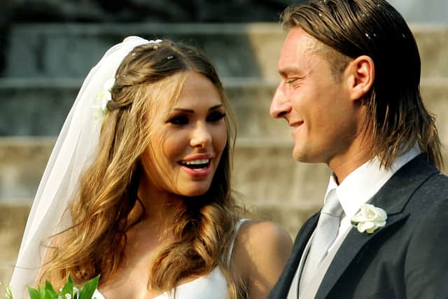 AS Roma captain Francesco Totti (R) smiles to his wife Italian TV star Hilary Blasi leave the church after their wedding 19 June 2005 in Rome. (Credit: VINCENZO PINTO/AFP via Getty Images)