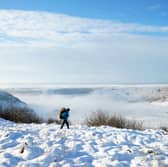 A person walks through snow above the Hole of Horcum at the North York Moors National Park. Snow is causing chaos on the other side of the country in Cumbria Pictire: Danny Lawson/PA Wire  



