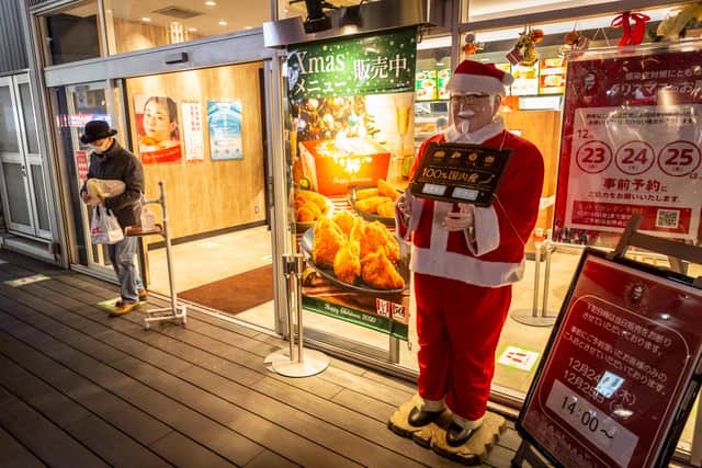 A man holding a Christmas meal box leaves a KFC restaurant on December 23, 2020 in Tokyo, Japan (Yuichi Yamazaki/Getty Images)