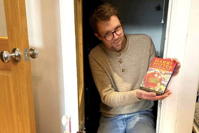 Jim Spencer with the book in the cupboard under the stairs at the seller's home. 
