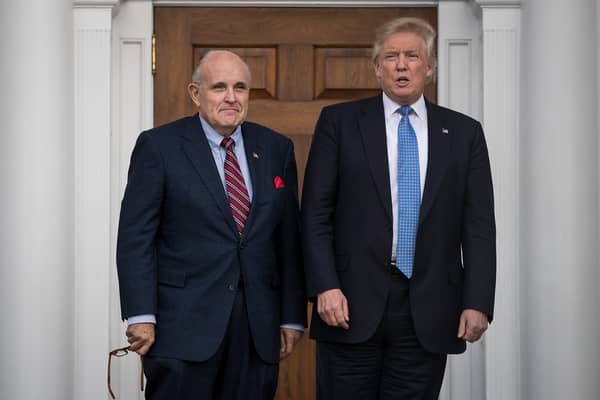 Former New York City mayor Rudy Giuliani stands with former President Donald Trump