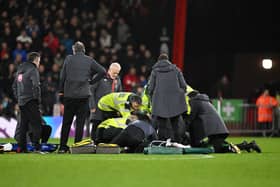 Tom Lockyer of Luton Town (obscured) receives medical treatment after collapsing during the Premier League match between AFC Bournemouth and Luton Town at Vitality Stadium