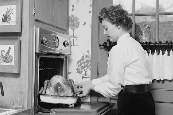 Circa 1955: A woman puts the turkey into the oven for christmas dinner. (Sherman/Three Lions/Getty Images)