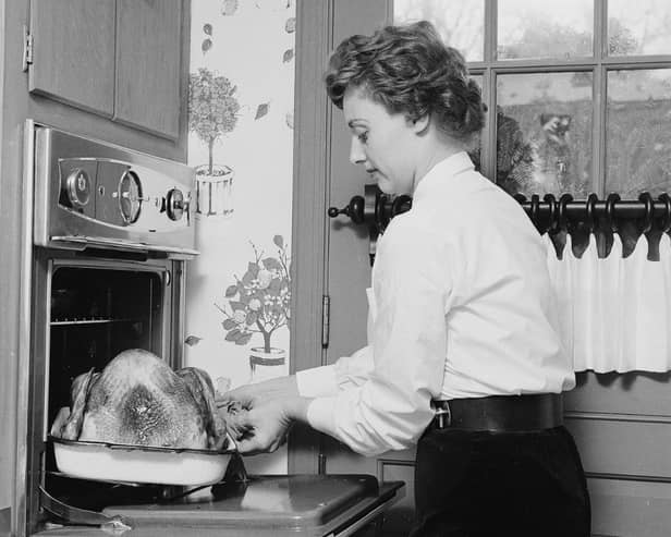 Circa 1955: A woman puts the turkey into the oven for christmas dinner. (Sherman/Three Lions/Getty Images)