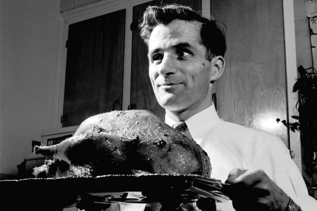 circa 1955: A man bringing a roast turkey to the table for a traditional Christmas dinner. (Photo by Evans/Three Lions/Getty Images)

