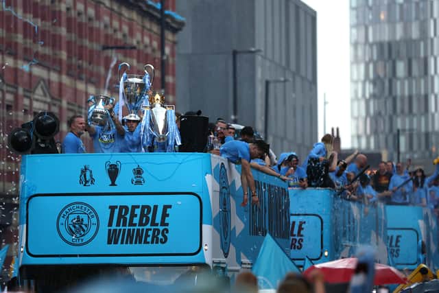 A general view as players of Manchester City celebrate on the Open-Top Bus, which read "Treble Winners" as fans line the streets
