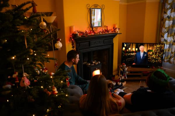 A family sits in a living room as they watch King Charles III delivering his first annual Christmas Day message in 2022