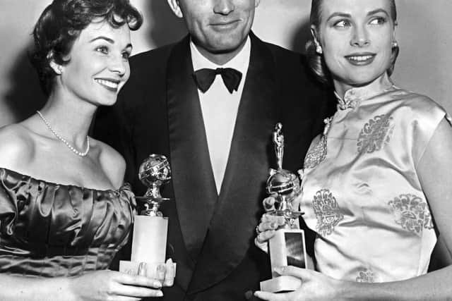 US actor Gregory Peck is surrounded 23 February 1956 by Grace Kelly (R), awarded Favorite Actress for "Henrietta" and Jean Simmons, named Best actress in a Musical Comedy during the 10th Annual Golden Globe Award in Hollywood. (Credit AFP/AFP via Getty Images)
