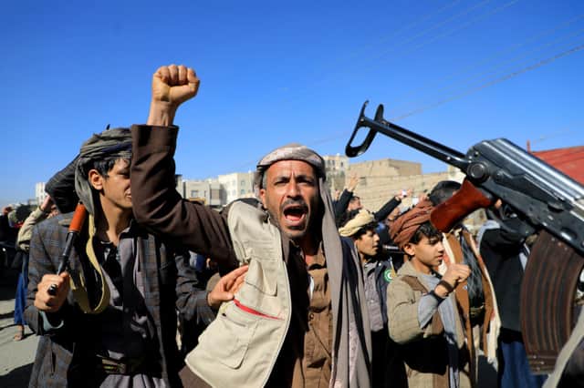 Houthi fighters brandish their weapons. The UK has launched airstrikes on Houthi military sites. Credit: Getty