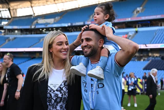 Manchester City's Algerian midfielder Riyad Mahrez celebrates with his wife Taylor Ward and their young daughter on the pitch after the presentation ceremony following the English Premier League football match between Manchester City and Chelsea at the Etihad Stadium in Manchester, north west England, on May 21, 2023 (Photo by OLI SCARFF/AFP via Getty Images)
